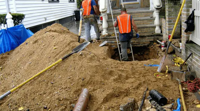 Contractors performing foundation protection and exterior drainage excavation near residential home steps in Allentown, PA